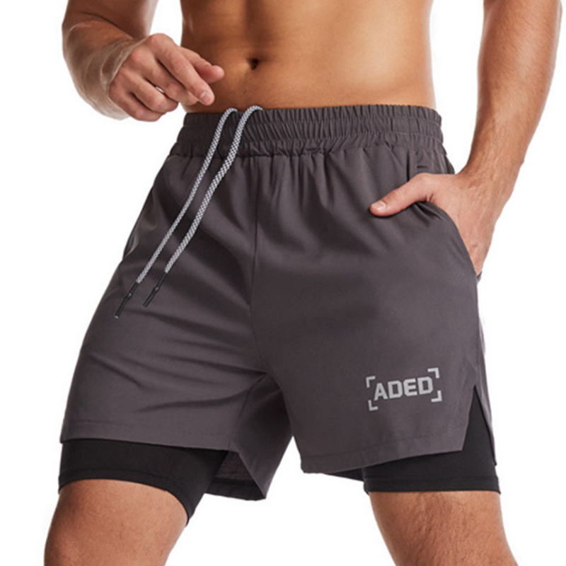 "Andningsbara dubbellager sportshorts för herrar med elastisk passform, praktiska fickor och inbyggda komprimerande tights."