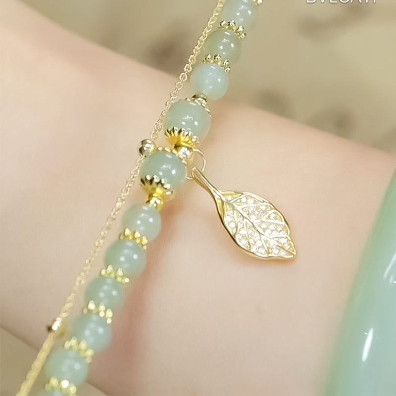 "Dame armband i grön jade med gulddekor, elegant smycke, grön sten och gyllene detaljer, perfekt accessoar för kvinnor."
