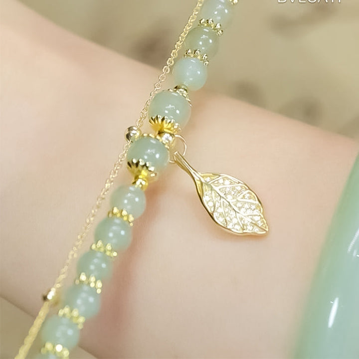 "Dame armband i grön jade med gulddekor, elegant smycke, grön sten och gyllene detaljer, perfekt accessoar för kvinnor."