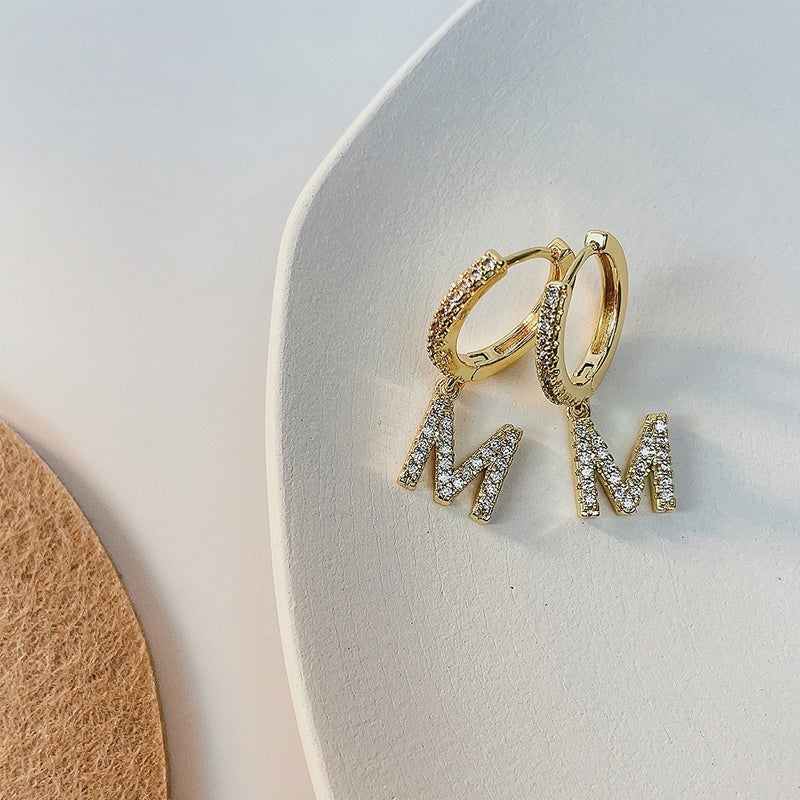 "Damhalsband i alfabetdesign med kubisk zirkon, elegant glansig finish, perfekt accessoar, visas i silver eller gyllene."