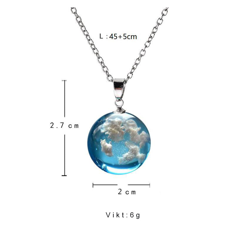 "Damhalsband i harts med blå himmel och vita moln, hjärtformad design, justerbar guldkedja 45 cm, elegant accessoar."
