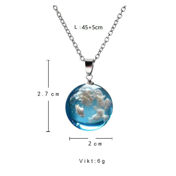 "Damhalsband i harts med blå himmel och vita moln, hjärtformad design, justerbar guldkedja 45 cm, elegant accessoar."
