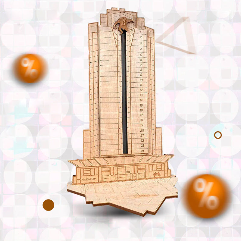 "Detaljerad trä Adventskalender med Die Hard-motiv, visar Hans Gruber faller från brunblå Nakatomi Plaza, roterbar design."