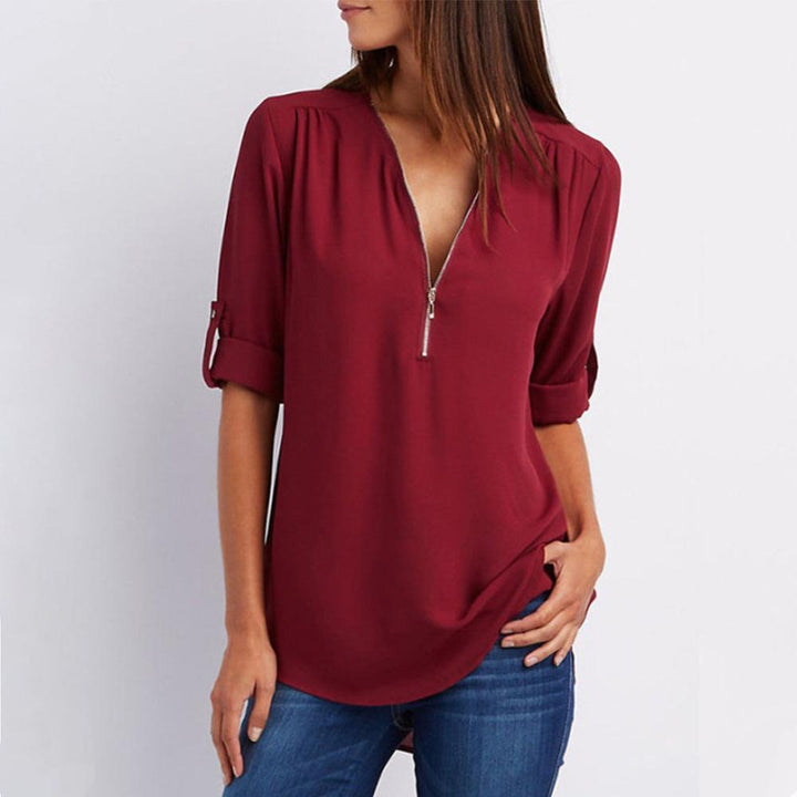 "Elegant damblusa med V-ringning och justerbar dragkedja, finns i flera färger; perfekt för stil och komfort."