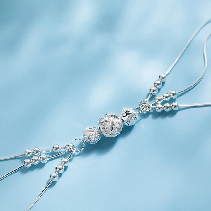 "Elegant justerbart pärlarmband för kvinnor i silver med sofistikerade pärlor och robust kopparmaterial, tidlös elegans."