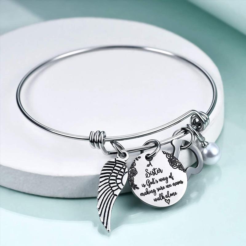 "Elegant justerbart syster charm armband i rostfritt stål, designat för damhandleder, med inspirerande text och hjärtsymbol."