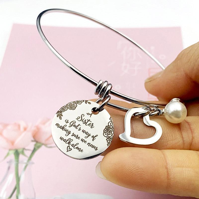"Elegant justerbart syster charm armband i rostfritt stål, designat för damhandleder, med inspirerande text och hjärtsymbol."