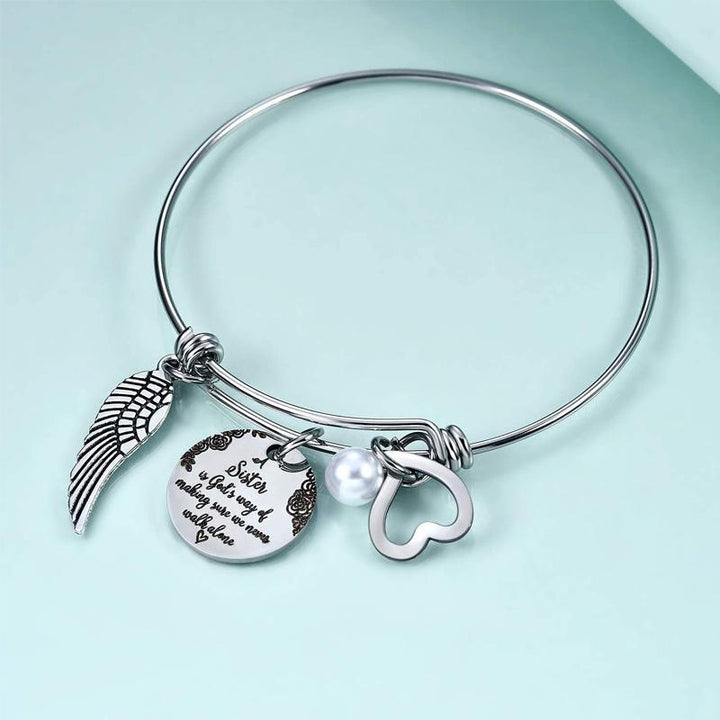 "Elegant justerbart syster charm armband i rostfritt stål, designat för damhandleder, med inspirerande text och hjärtsymbol."