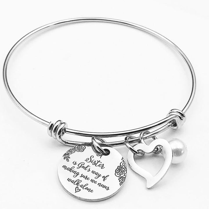 "Elegant justerbart syster charm armband i rostfritt stål, designat för damhandleder, med inspirerande text och hjärtsymbol."