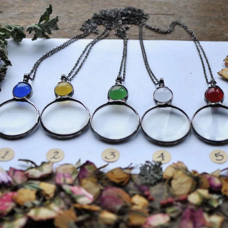 "Elegant kvinnligt hänge halsband med förstoringsglas i unikt design, finns i gul, röd, grön, blå, transparent."