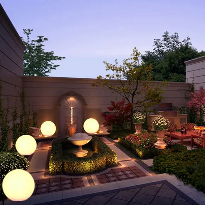 "Elegant LED-solcellslampa för gräsmatta med kulvit design, silverdetaljer och varm belysning för trädgårdar."