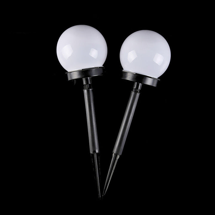 "Elegant LED-solcellslampa för gräsmatta med kulvit design, silverdetaljer och varm belysning för trädgårdar."