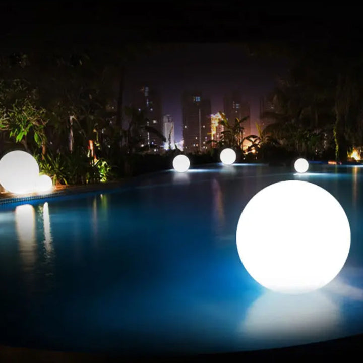 "Elegant LED-solcellslampa för gräsmatta med kulvit design, silverdetaljer och varm belysning för trädgårdar."