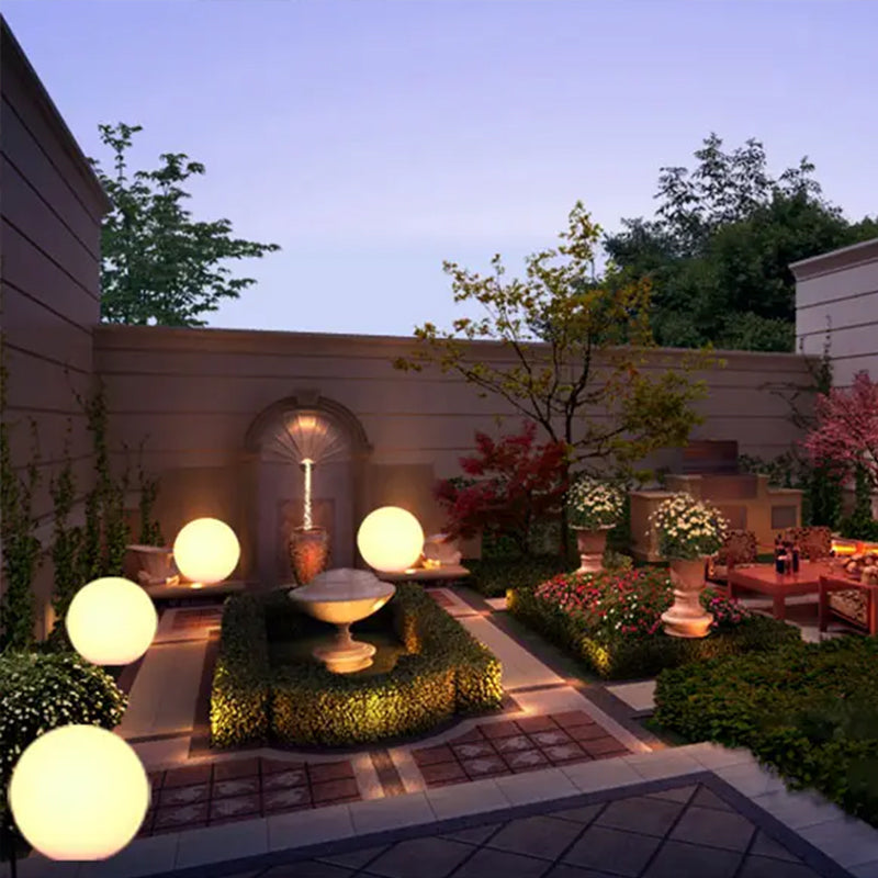 "Elegant LED-solcellslampa för gräsmatta med kulvit design, silverdetaljer och varm belysning för trädgårdar."