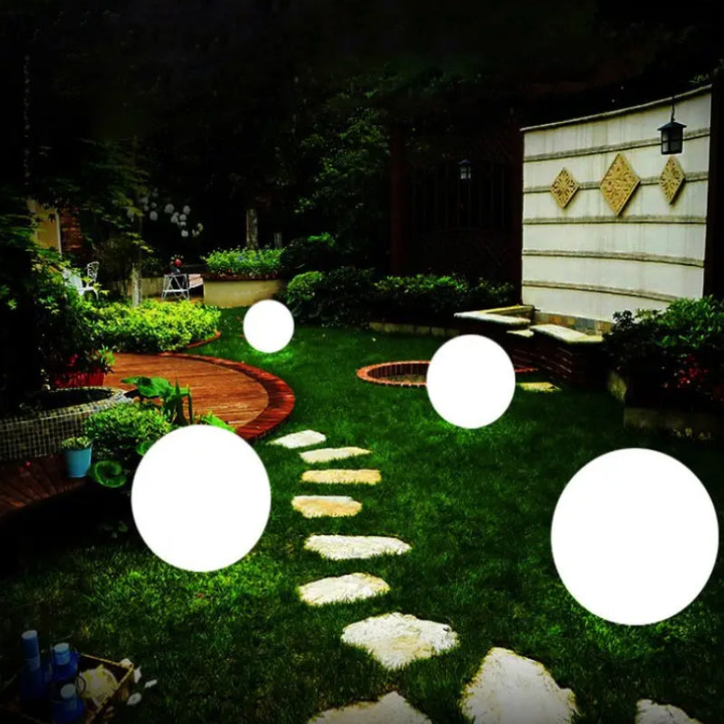 "Elegant LED-solcellslampa för gräsmatta med kulvit design, silverdetaljer och varm belysning för trädgårdar."