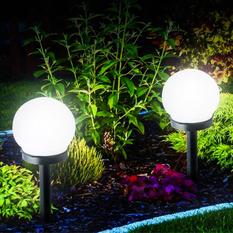 "Elegant LED-solcellslampa för gräsmatta med kulvit design, silverdetaljer och varm belysning för trädgårdar."