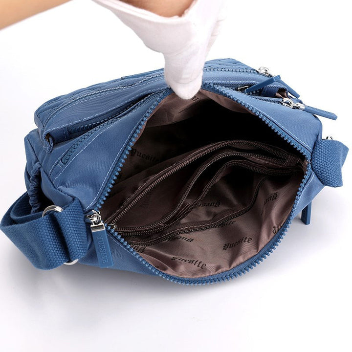 "Elegant nylon axelväska för kvinnor, med flera fack, justerbar rem och lyxig design, finns i olika färger."
