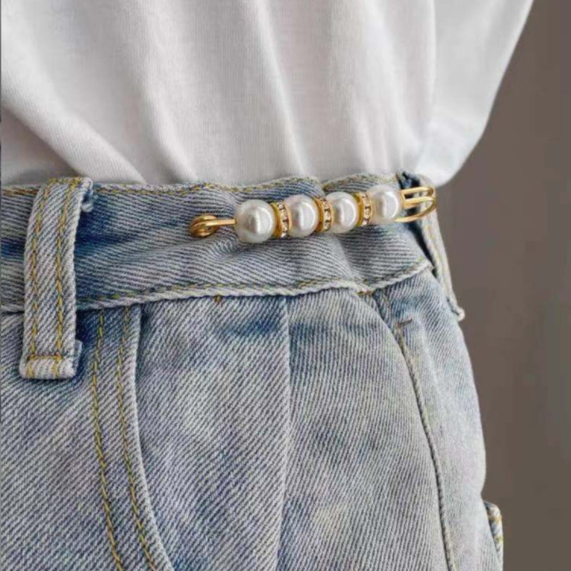 "Elegant säkerhetsnålsbrosch med vita pärlor och strass, perfekt för damkläder, i svart och vitt för stil och matchning."