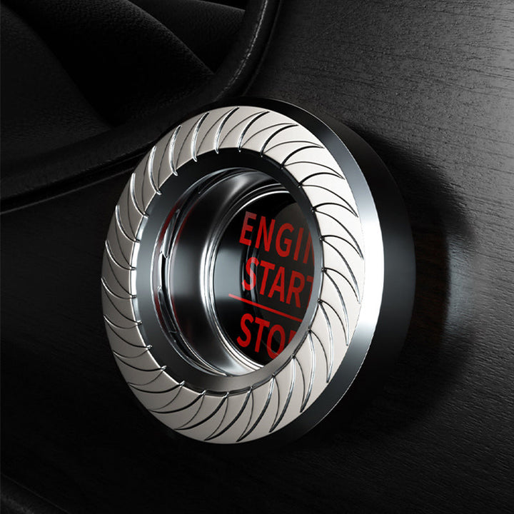 "Elegant skyddskåpa för tändningsknapp i reptålig zinklegering, silver, för sofistikerad bilinteriör."