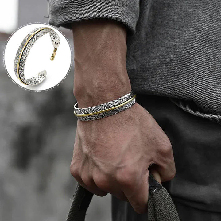 Elegant vintage fjäderarmband för damer i justerbart silver och guld, retro stil med symbolisk fjäderdetalj.