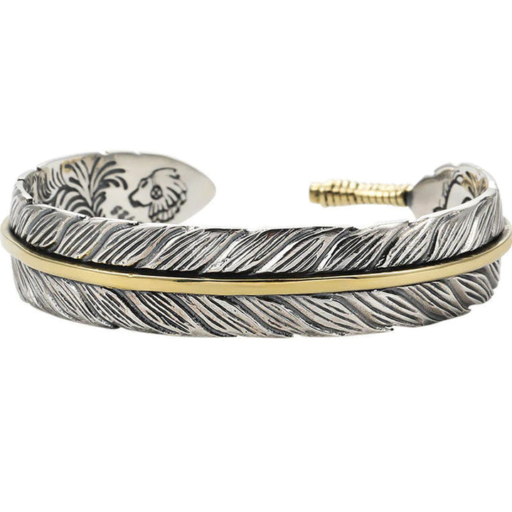 Elegant vintage fjäderarmband för damer i justerbart silver och guld, retro stil med symbolisk fjäderdetalj.