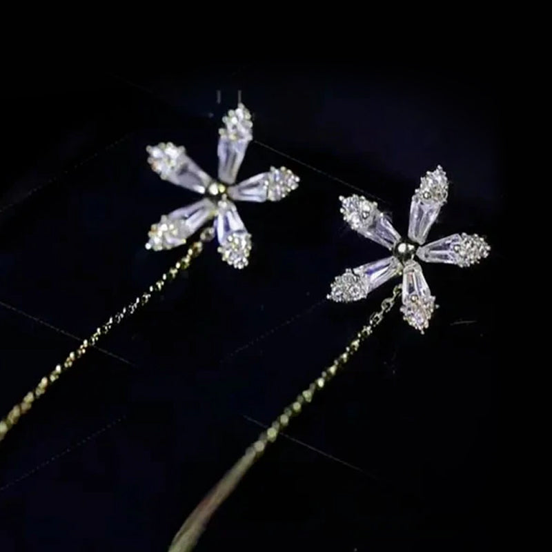 "Eleganta blomsterörhängen med strass och fransar som glänser i ljuset, perfekta för en sofistikerad damstil."