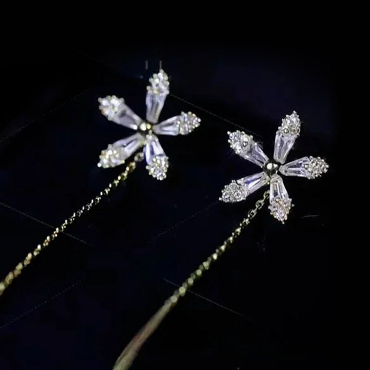 "Eleganta blomsterörhängen med strass och fransar som glänser i ljuset, perfekta för en sofistikerad damstil."
