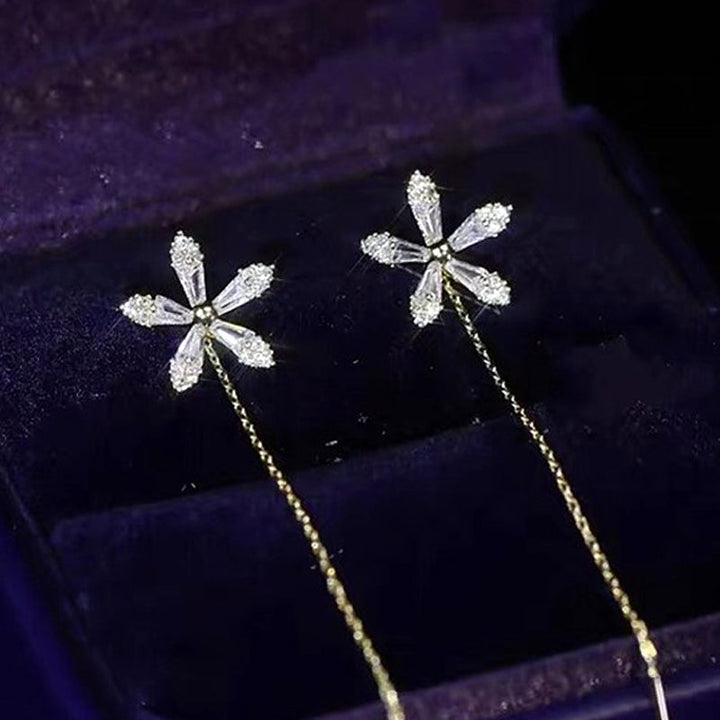 "Eleganta blomsterörhängen med strass och fransar som glänser i ljuset, perfekta för en sofistikerad damstil."