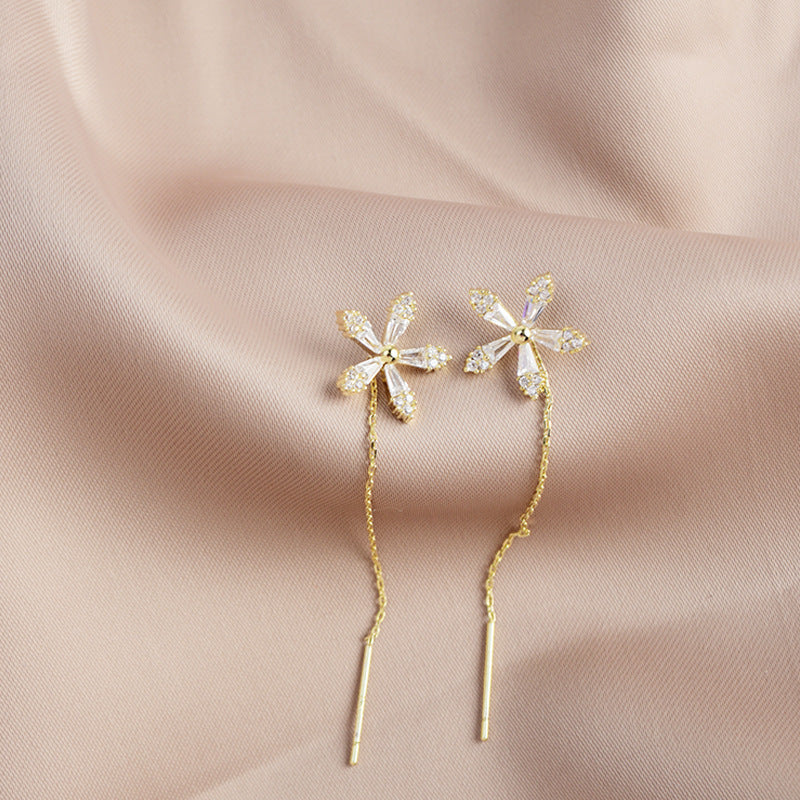 "Eleganta blomsterörhängen med strass och fransar som glänser i ljuset, perfekta för en sofistikerad damstil."