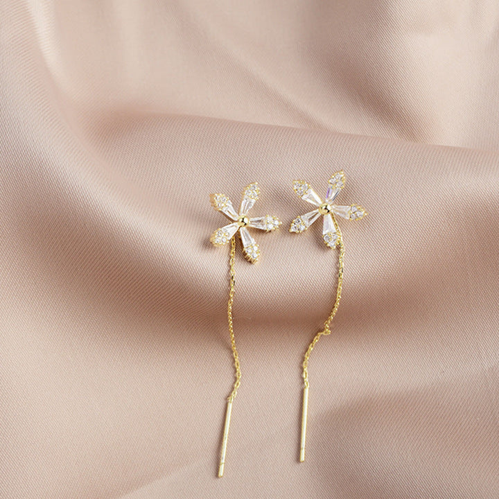 "Eleganta blomsterörhängen med strass och fransar som glänser i ljuset, perfekta för en sofistikerad damstil."