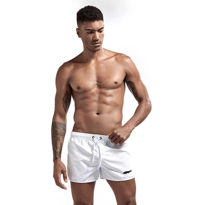 "Enfärgade herr badshorts med krokodilmönster i polyester, perfekt för sommar, tillgängliga i flera färger."