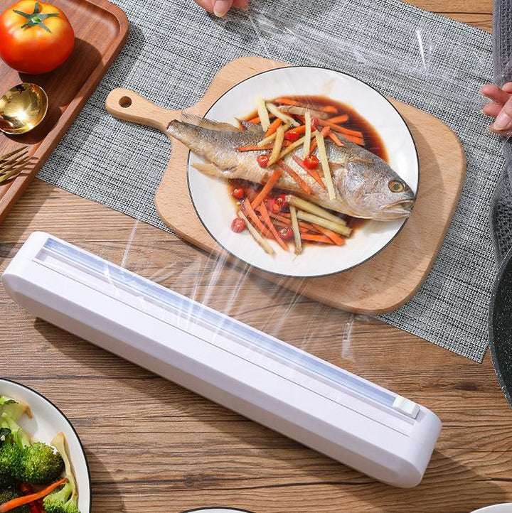 "Ergonomisk plastfolieskärare i vitt med magnetfäste, modern design, skär plast- och aluminiumfolie effektivt."