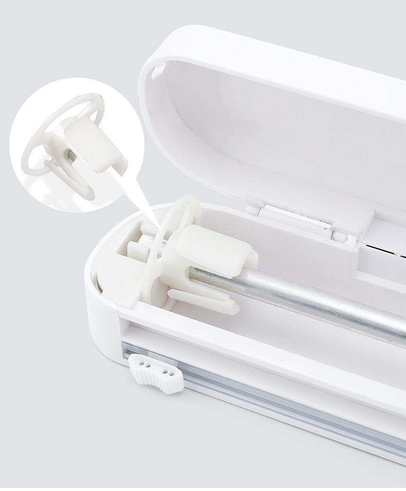 "Ergonomisk plastfolieskärare i vitt med magnetfäste, modern design, skär plast- och aluminiumfolie effektivt."