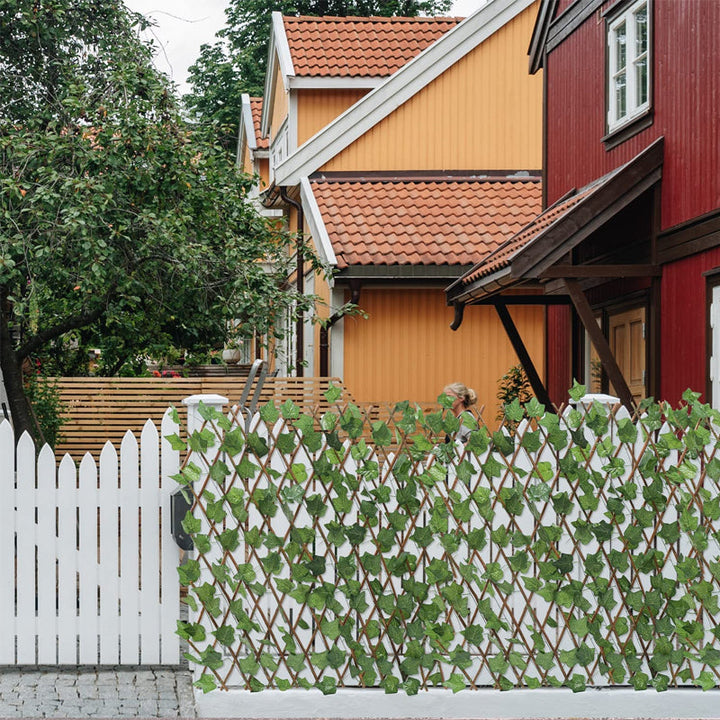 "Expanderbart mörk- och ljusgrönt trädgårdsstaket med konstgjorda blad, perfekt för avskildhet och dekoration i trädgården."
