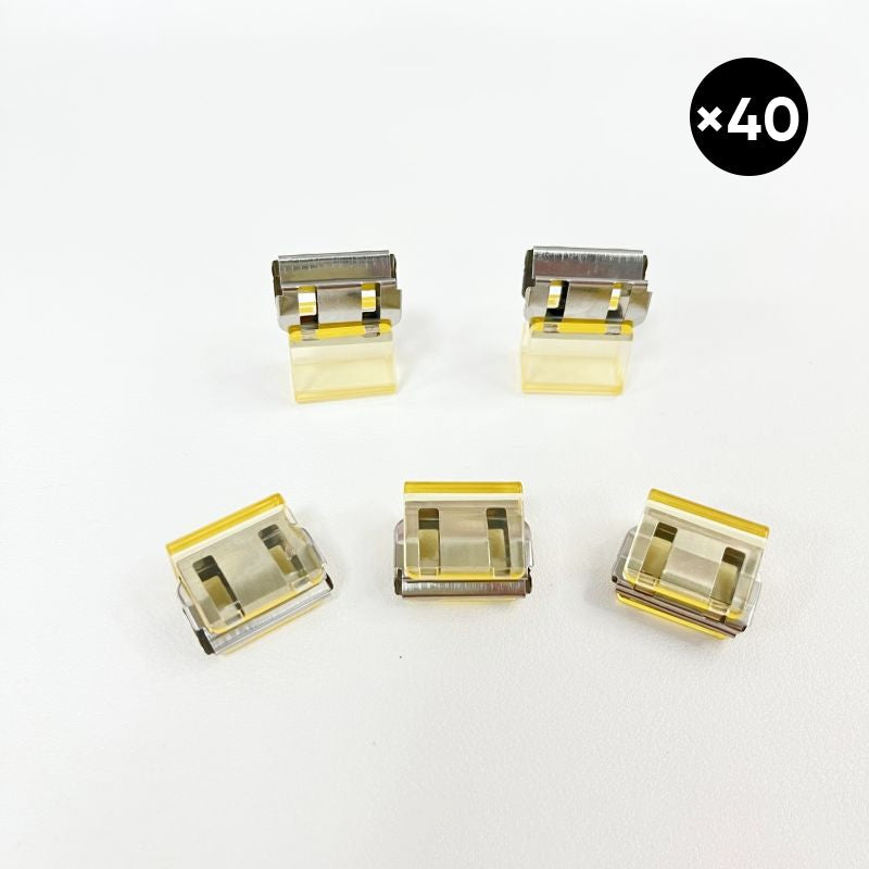 "Färgglada metallpappersklämmor i grönt, gult, lila, rosa, transparent och blått, perfekt för kontor och skola."