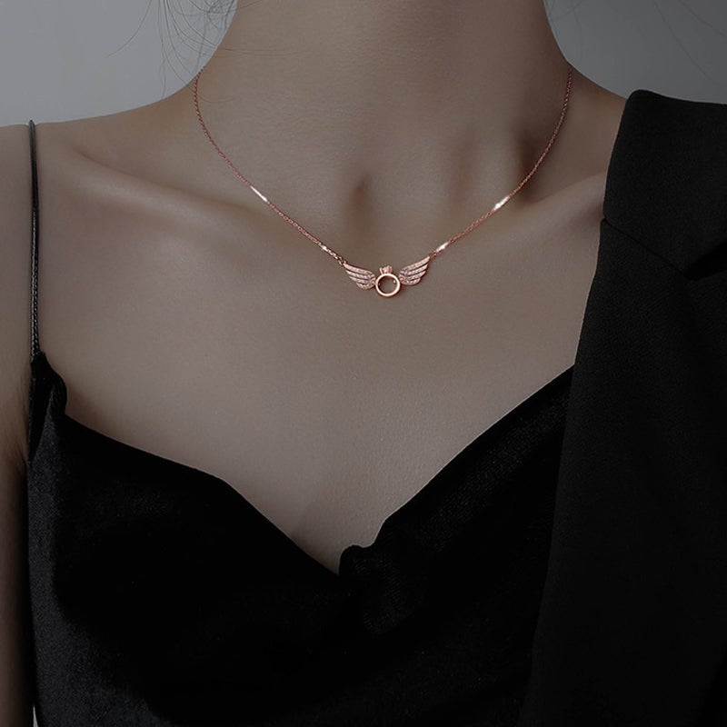"Glänsande kvinnligt halsband med detaljerade änglavingar i guld, silver och roséguld, perfekt för alla tillfällen."