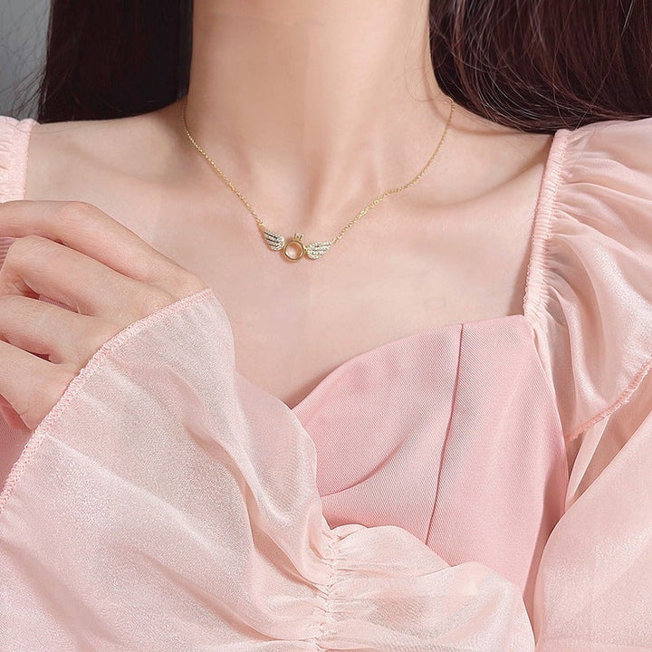 "Glänsande kvinnligt halsband med detaljerade änglavingar i guld, silver och roséguld, perfekt för alla tillfällen."