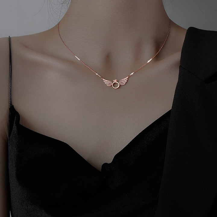 "Glänsande kvinnligt halsband med detaljerade änglavingar i guld, silver och roséguld, perfekt för alla tillfällen."