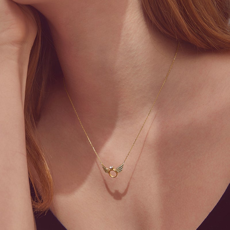 "Glänsande kvinnligt halsband med detaljerade änglavingar i guld, silver och roséguld, perfekt för alla tillfällen."
