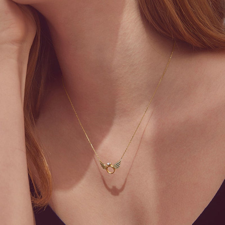 "Glänsande kvinnligt halsband med detaljerade änglavingar i guld, silver och roséguld, perfekt för alla tillfällen."