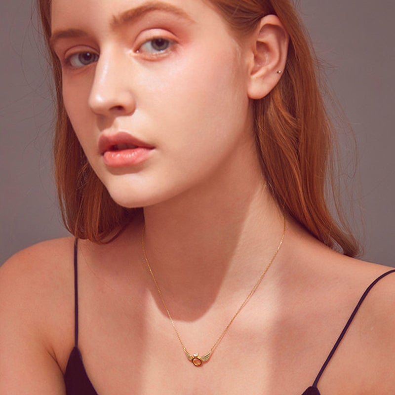 "Glänsande kvinnligt halsband med detaljerade änglavingar i guld, silver och roséguld, perfekt för alla tillfällen."