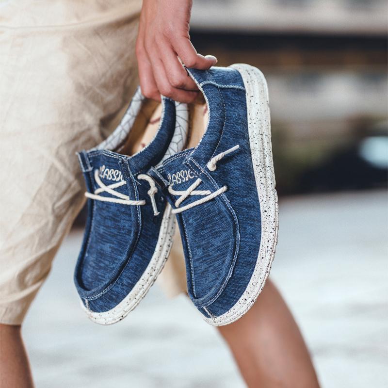 "Grå herrcanvas skor med glid-på design, bred passform och bomullsduk. Perfekta för vardagligt bruk och enkla att rengöra."