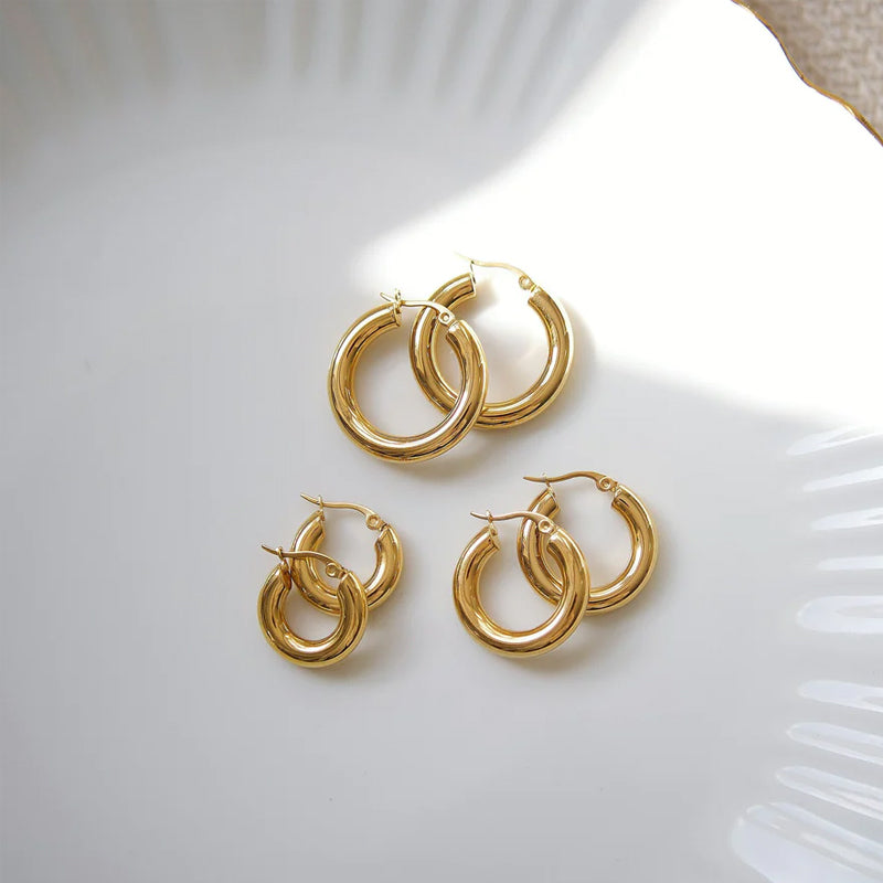 Guldfärgade ringörhängen i rostfritt stål, olika storlekar, elegant look för alla tillfällen och stilpreferenser.