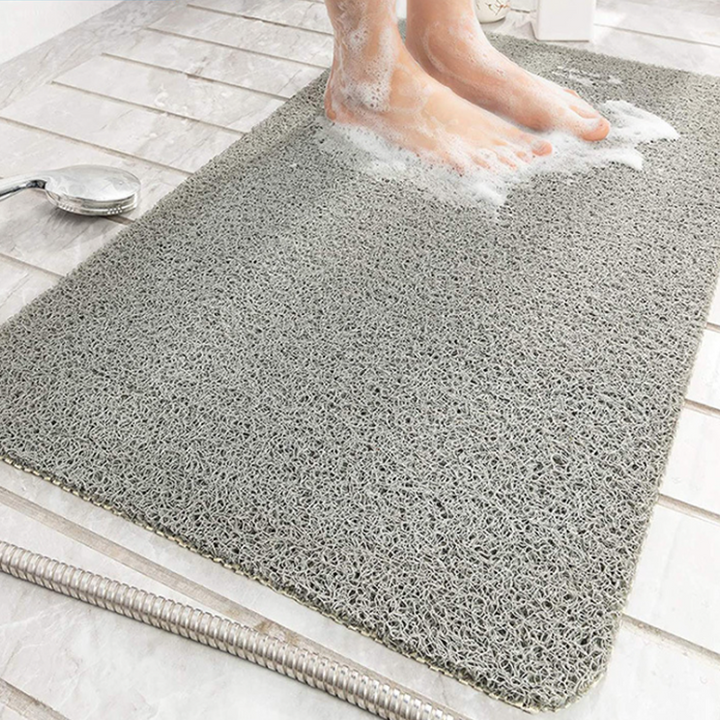 "Halkfri badrumsmatta i PVC, grå/beige, med dräneringshål för säkerhet och komfort i badrummet."