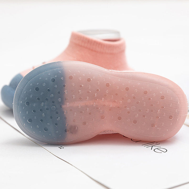 "Halkfria barnstrumpor med djurmotiv, flexibla sulor och elastisk topp, perfekt för små barns naturliga fotutveckling."