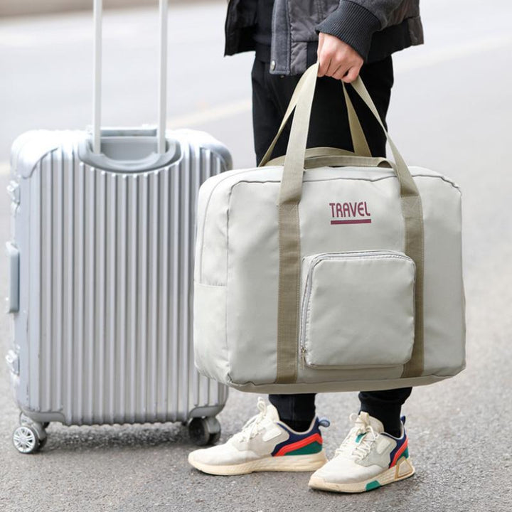 "Hållbar hopfällbar resväska i grå nylon med extra kapacitet; lätt, unisex design för resor och vardagspendling."