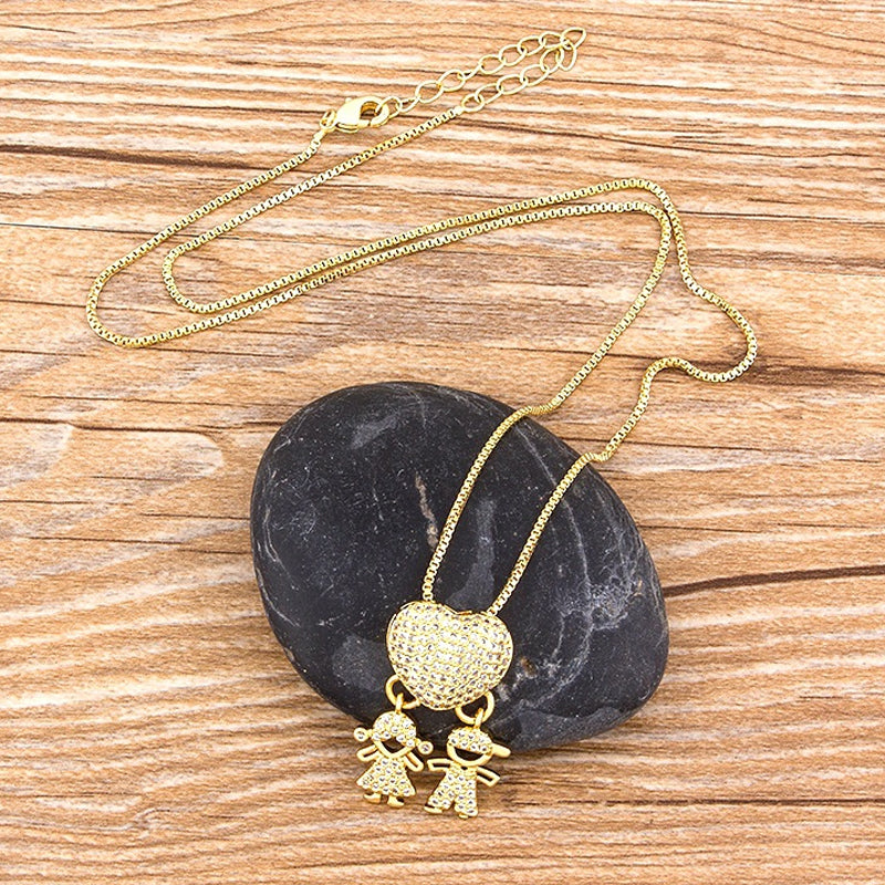 "Halsband i guldplätering med intrikat design av mor och barn, dekorerad med kubiska zirkonia. Perfekt för mammor."