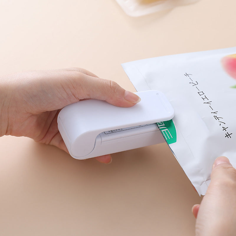 "Handhållen värmepåsförseglare för kök, kompakt och batteridriven med säkerhetsklämma, ideal för försegling av plastpåsar."