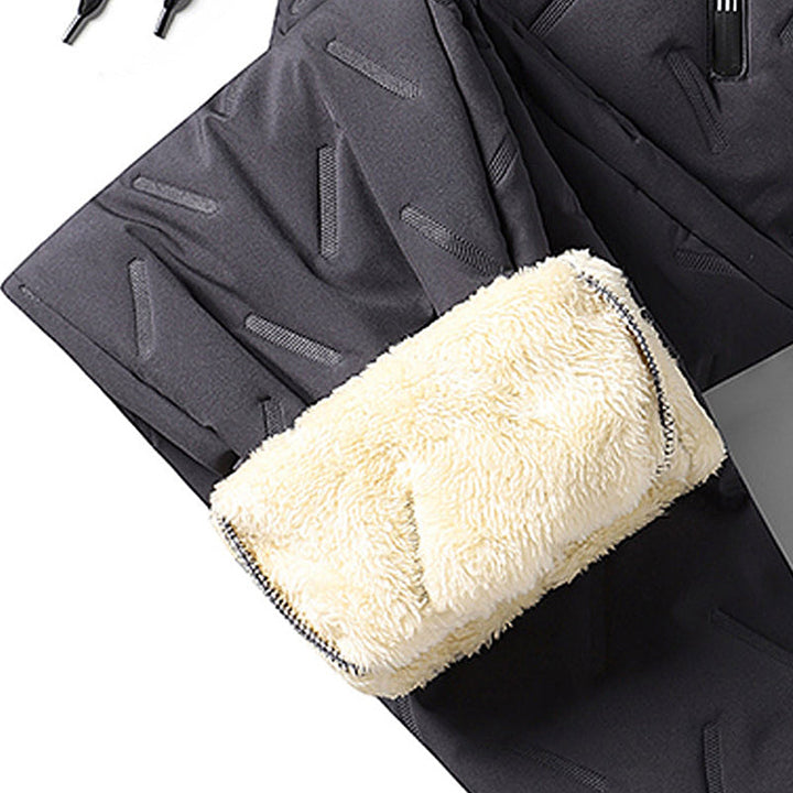 "Herr vinterfleece byxor med resårband, platt benöppning, mörk färg, varm fleece, stilren look för kalla dagar."
