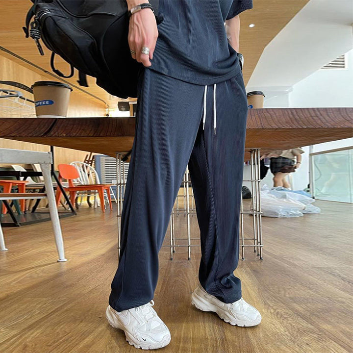 "Herrbyxset av is-silke, rund hals, vita elastiska byxor, praktiska fickor, avslappnad passform, stilren design"